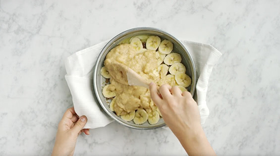 Pour batter on top of the banana slices in the pan and spread into an even layer.
